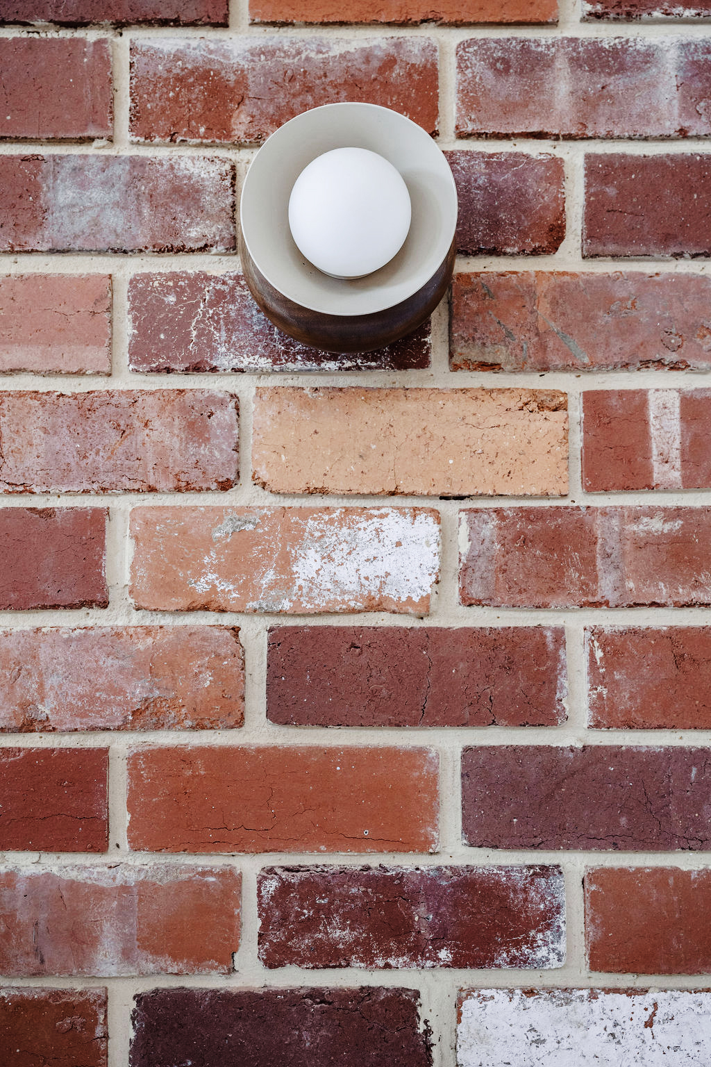 Detail of red brick wall with round exterior light fixture