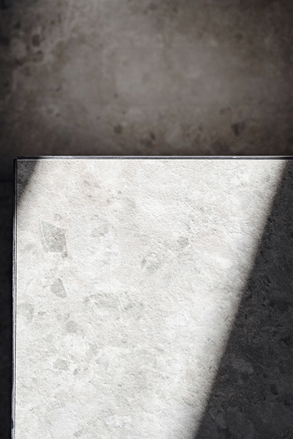 Textured stone surface illuminated by angled beam of sunlight